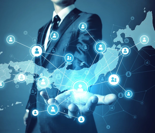 Glowing blue digital network map of Japan with interconnected user profile icons, overlaid on a businessman's open hand.